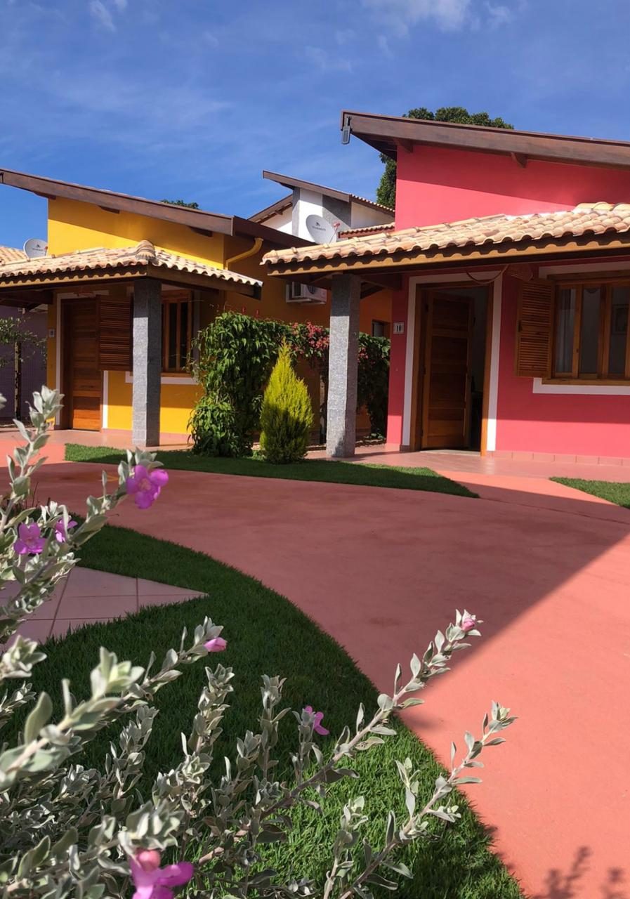 Chalés Jardim coloridos com varanda e áreas verdes da pousada