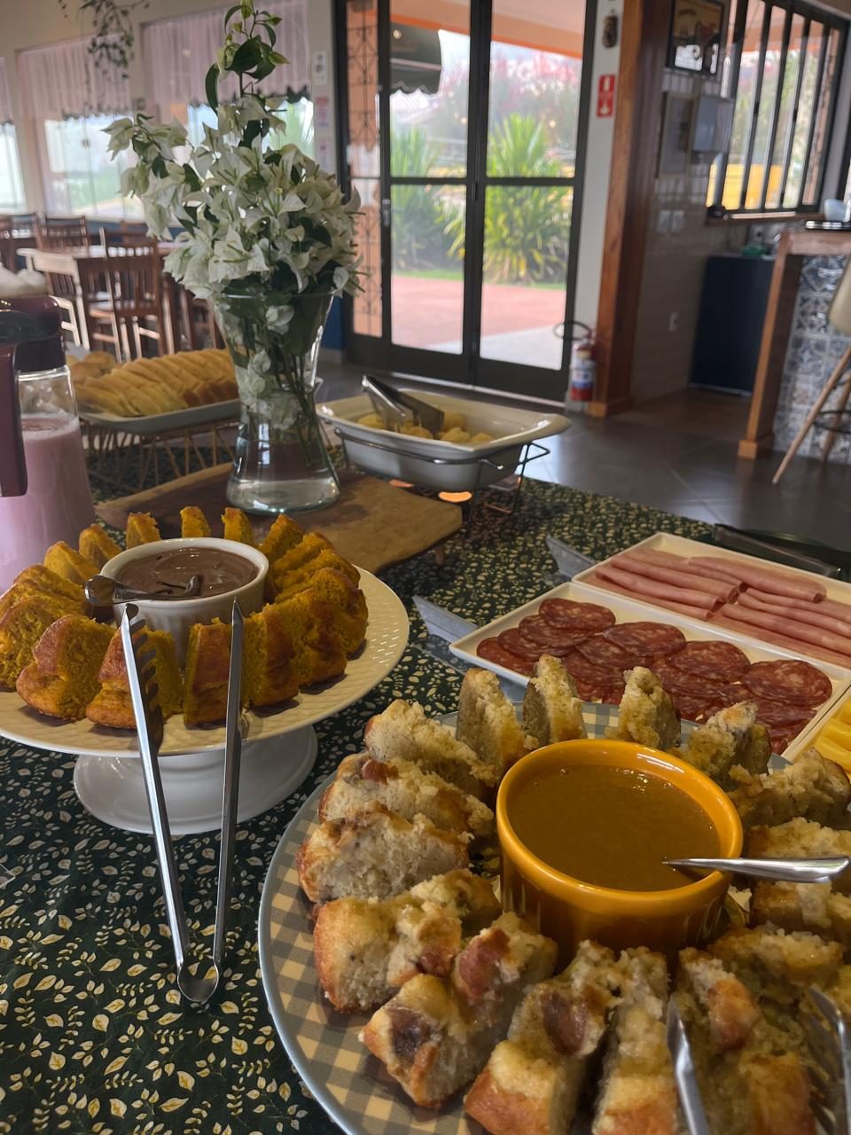 Café da manhã artesanal com bolos caseiros, pães e frios