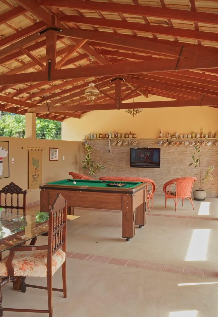 Área de convivência coberta com sinuca, TV e mesa de jantar